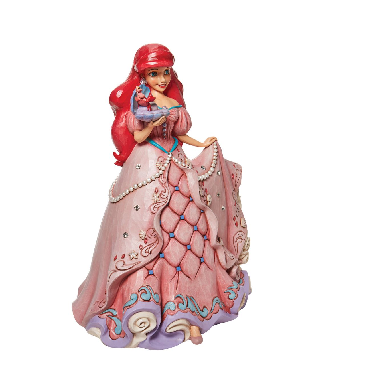 "A Precious Pearl" Second in the Series of Deluxe Figurines, The Enchanted Princess Series, is this striking 40cm Ariel Figurine. Thanks to the magic of a mysterious sea witch, Ariel The Little Mermaid, grows legs to walk on land. This sparkling Jim Shore figurine features the princess at her prettiest, her gown fitted with shells and jewels, she holds an oyster with a pearl.