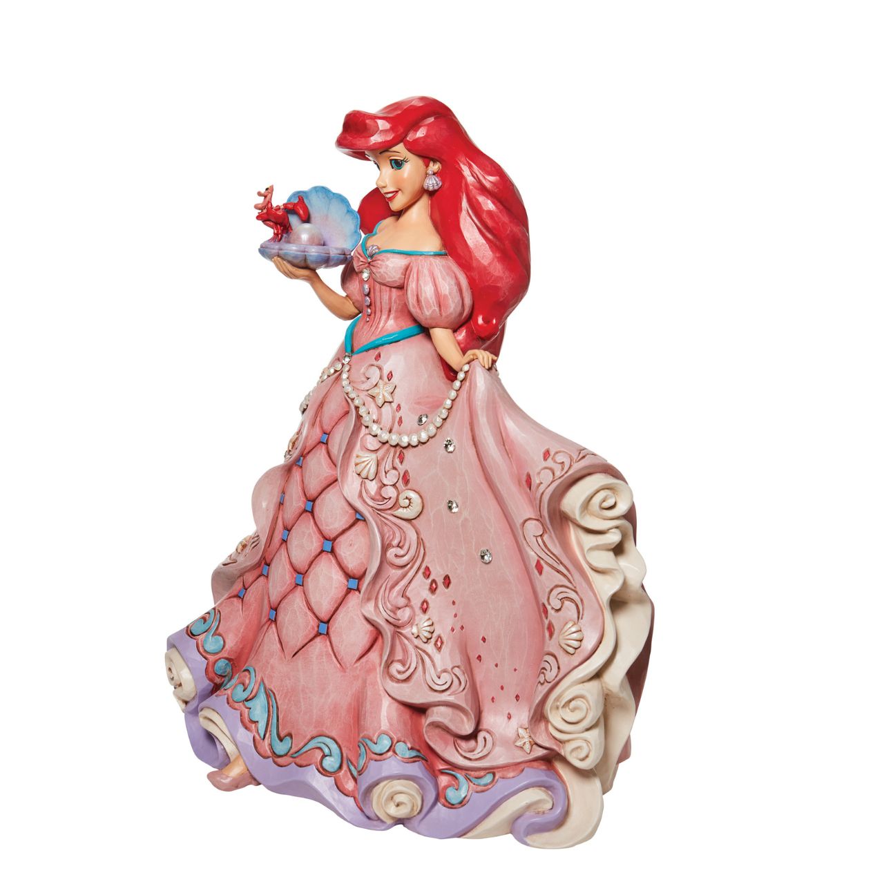 "A Precious Pearl" Second in the Series of Deluxe Figurines, The Enchanted Princess Series, is this striking 40cm Ariel Figurine. Thanks to the magic of a mysterious sea witch, Ariel The Little Mermaid, grows legs to walk on land. This sparkling Jim Shore figurine features the princess at her prettiest, her gown fitted with shells and jewels, she holds an oyster with a pearl.