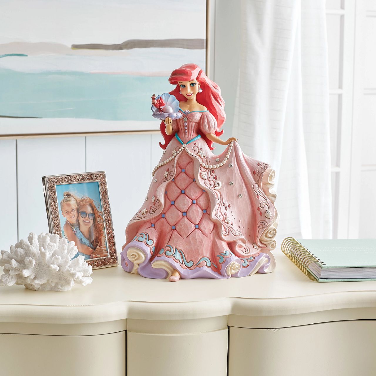 "A Precious Pearl" Second in the Series of Deluxe Figurines, The Enchanted Princess Series, is this striking 40cm Ariel Figurine. Thanks to the magic of a mysterious sea witch, Ariel The Little Mermaid, grows legs to walk on land. This sparkling Jim Shore figurine features the princess at her prettiest, her gown fitted with shells and jewels, she holds an oyster with a pearl.