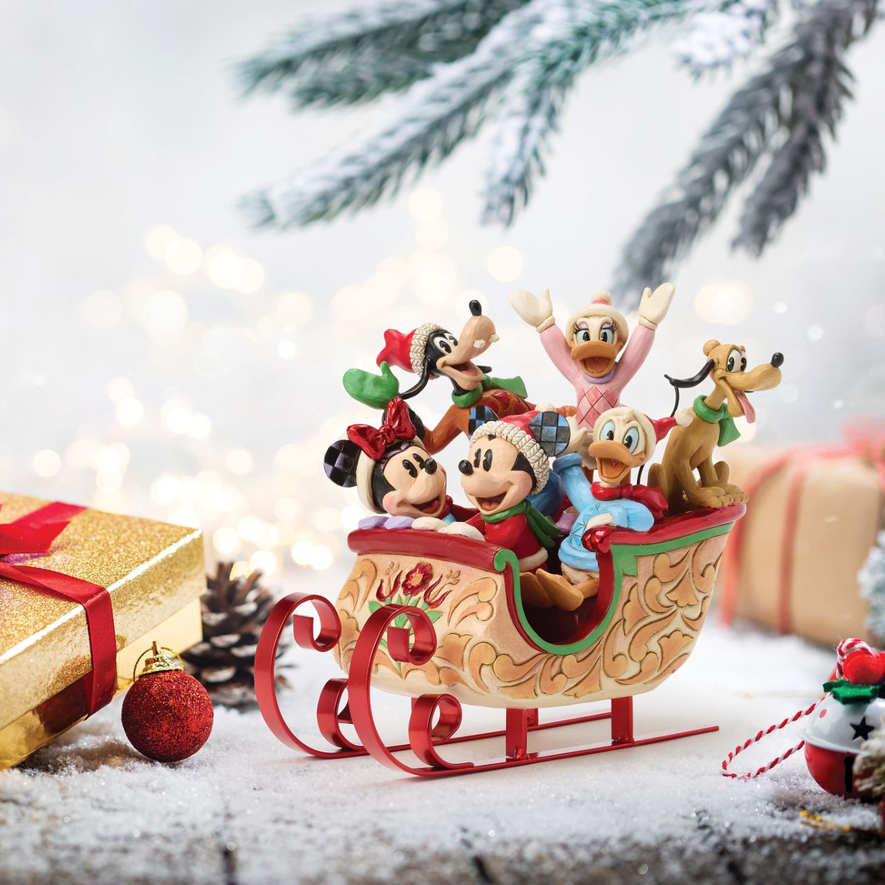 Celebrate the season with Jim Shore's enchanting Christmas sleigh ride featuring Mickey, Minnie, Donald, Daisy, Goofy, and Pluto bundled together in a beautifully crafted sleigh. Decorated with vibrant rosemaling patterns and gleaming metal runners.