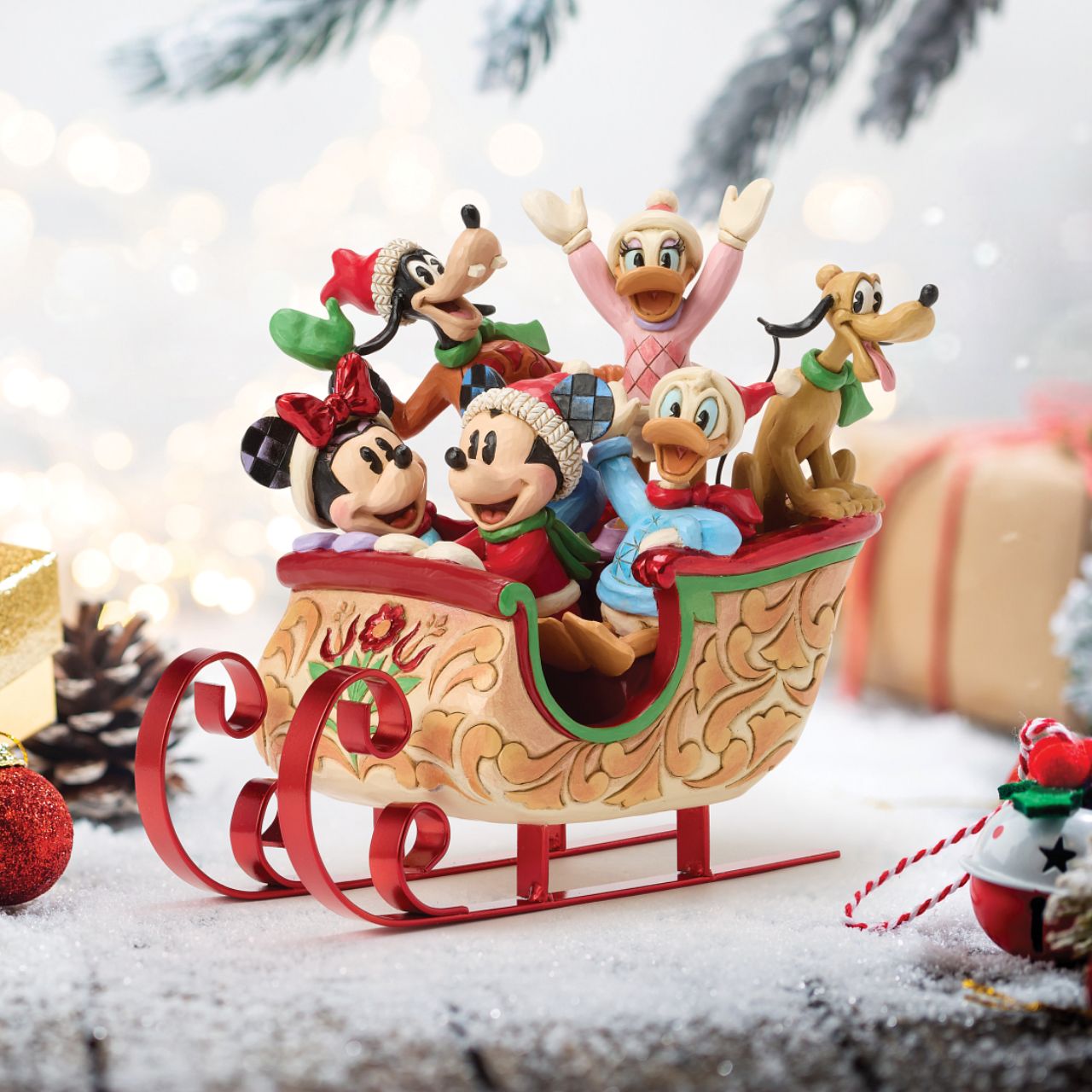 Celebrate the season with Jim Shore's enchanting Christmas sleigh ride featuring Mickey, Minnie, Donald, Daisy, Goofy, and Pluto bundled together in a beautifully crafted sleigh. Decorated with vibrant rosemaling patterns and gleaming metal runners.