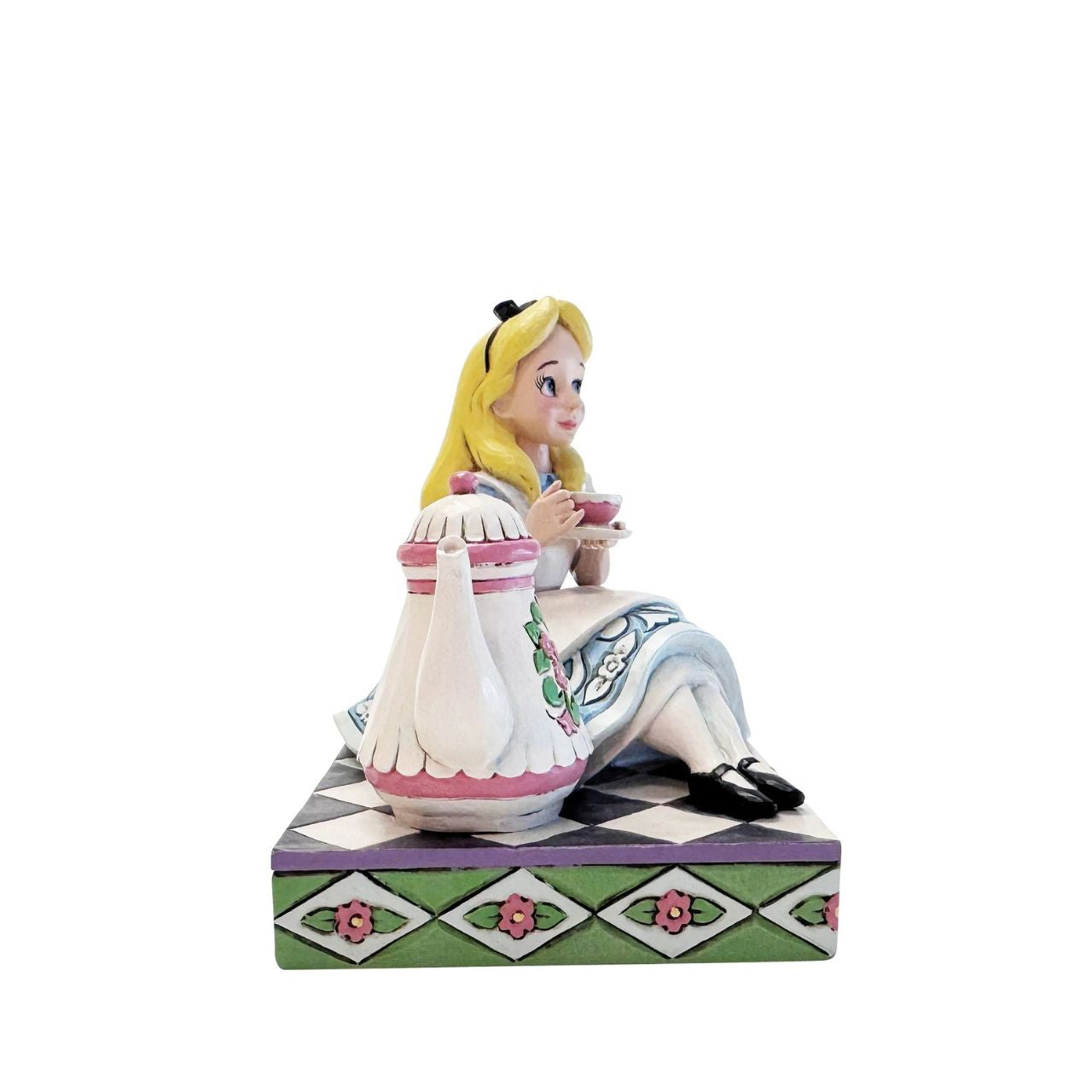 Alice sips beside a giant teapot in this whimsical Jim Shore creation. Inspired by Alice in Wonderland, this charming scene celebrates the imagination, playfulness, and magic of Disney's most curious tea party.