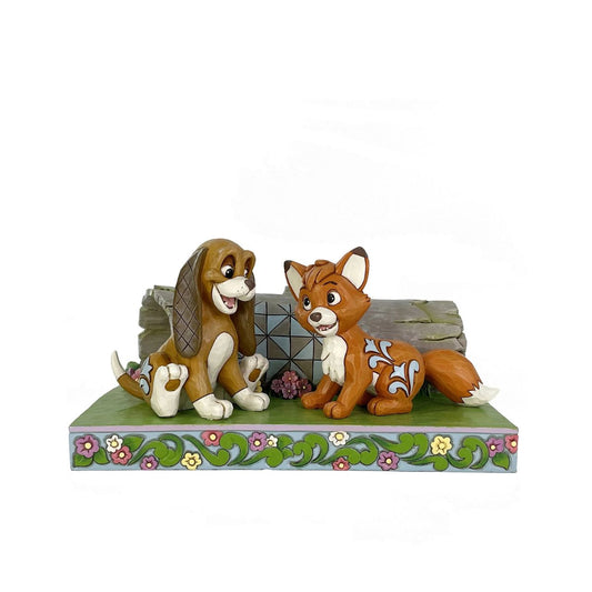 Celebrate the unlikely friendship between Fox and the Hound in this charming Jim Shore scene. As they play in the woods, Jim Shore's iconic rosemaling, patchwork patterns, and floral details bring the vibrant scene to life.