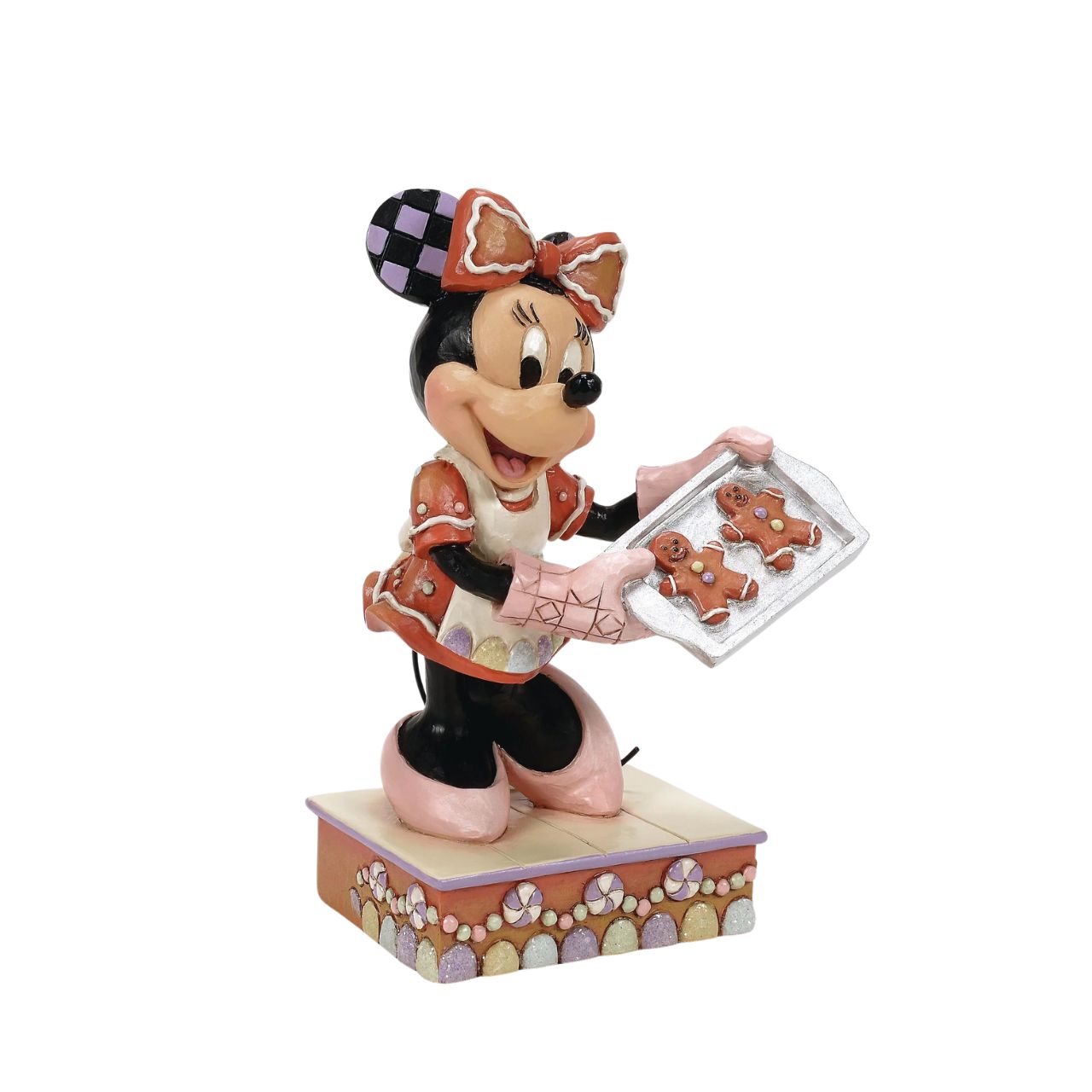 Dressed in a delightful gingerbread-inspired dress and bow, Minnie Mouse shares freshly baked cookies in this heartwarming Jim Shore scene. Standing on a stage of colourful candy, Minnie brings the warmth and sweetness of the season to life.