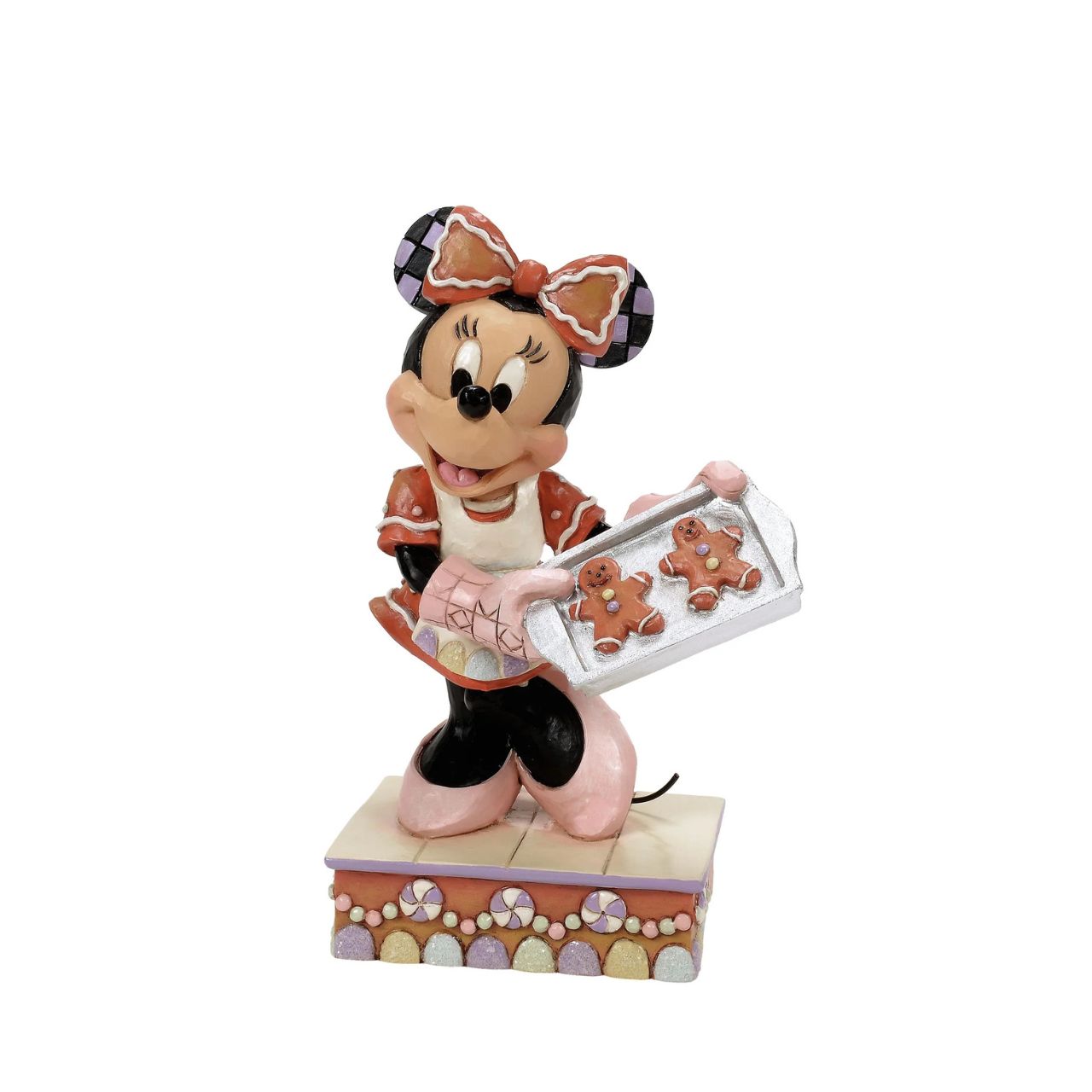 Dressed in a delightful gingerbread-inspired dress and bow, Minnie Mouse shares freshly baked cookies in this heartwarming Jim Shore scene. Standing on a stage of colourful candy, Minnie brings the warmth and sweetness of the season to life.