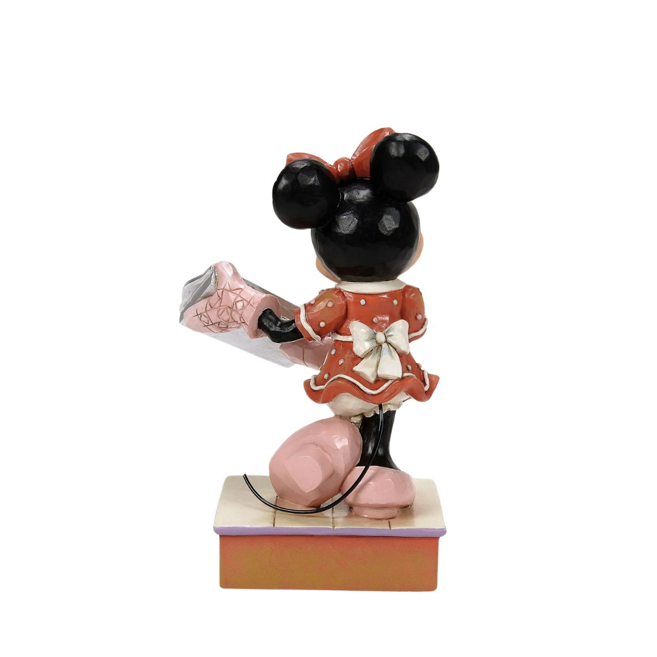 Dressed in a delightful gingerbread-inspired dress and bow, Minnie Mouse shares freshly baked cookies in this heartwarming Jim Shore scene. Standing on a stage of colourful candy, Minnie brings the warmth and sweetness of the season to life.