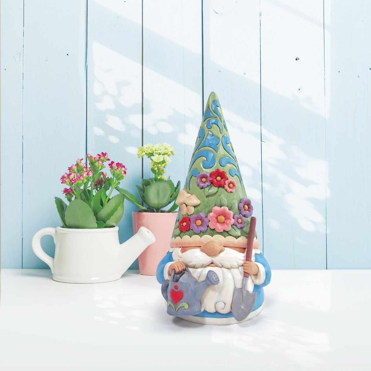 "Bloom and Grow" For centuries, gnomes have been symbols of good luck, they are thought to provide protection with their delightful charm. This Jim Shore gnome is ready to garden, and wears a flower and fungi patterned hat while holding a watering can and shovel. Suitable for indoor/outdoor use.