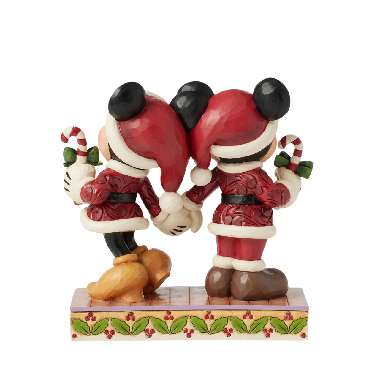 In this festive Jim Shore scene, Mickey and Minnie Mouse don Santa suits adorned with intricate rosemaling patterns and joyfully carry candy canes. Their bright smiles radiate holiday cheer, making the scene a delightful celebration of the season.