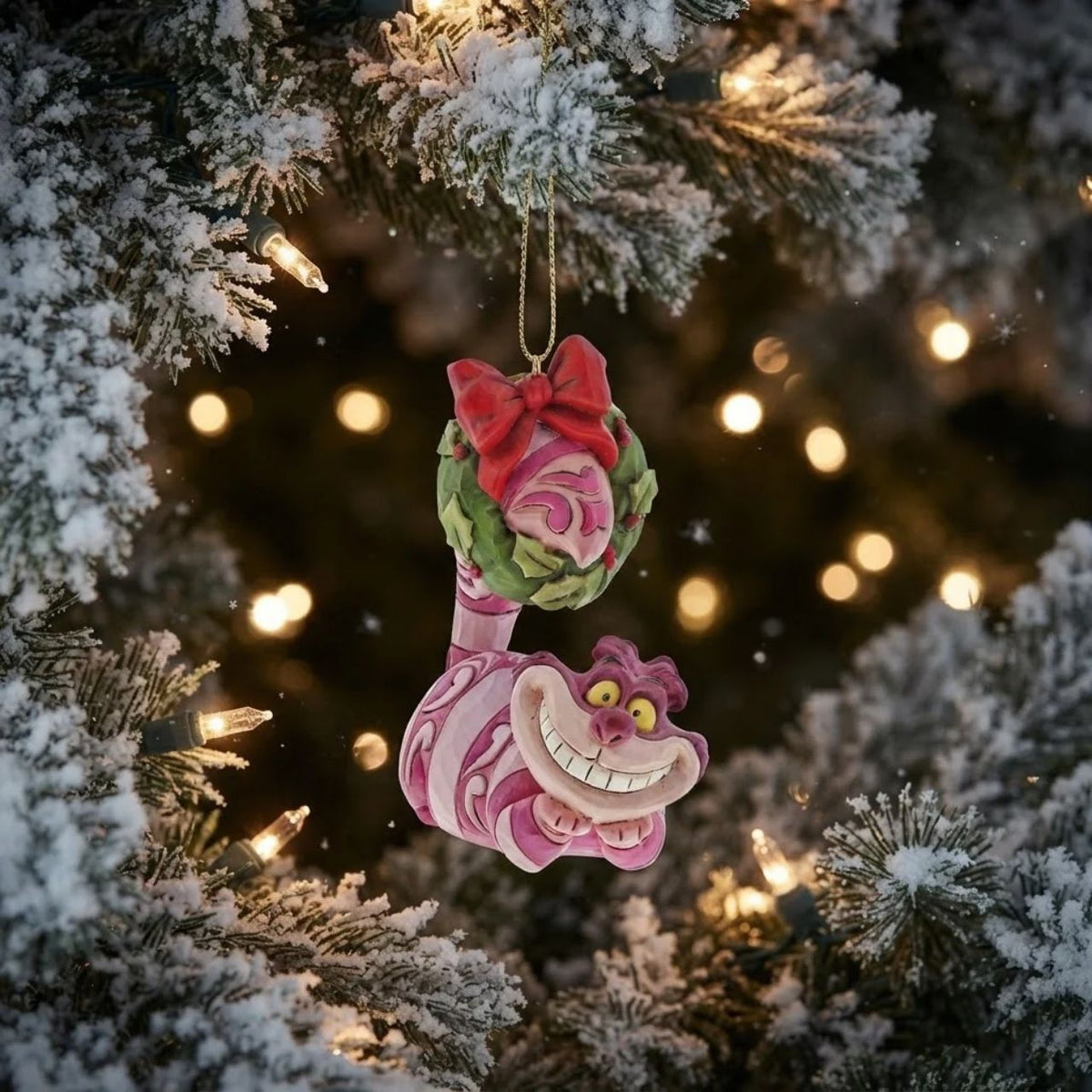 Cheshire cat, the king of blending in, turns his tail into a Christmas wreath in this fun Jim Shore design bauble. Smiling his classic toothy grin, this mischievous cat might try to snatch your Christmas candy, so keep both eyes on him this Christmas.