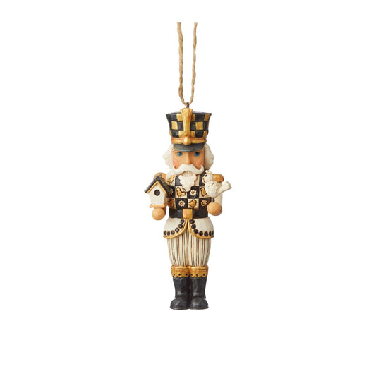 Christmas Black and Gold Nutcracker Hanging Ornament  Jim Shore's stunning Black & Gold collection features unmistakable style finished with striking, contrasting colour. This eye-catching Nutcracker ornament brings traditional design to modern colour with a whimsical touch of birdhouse and bird.