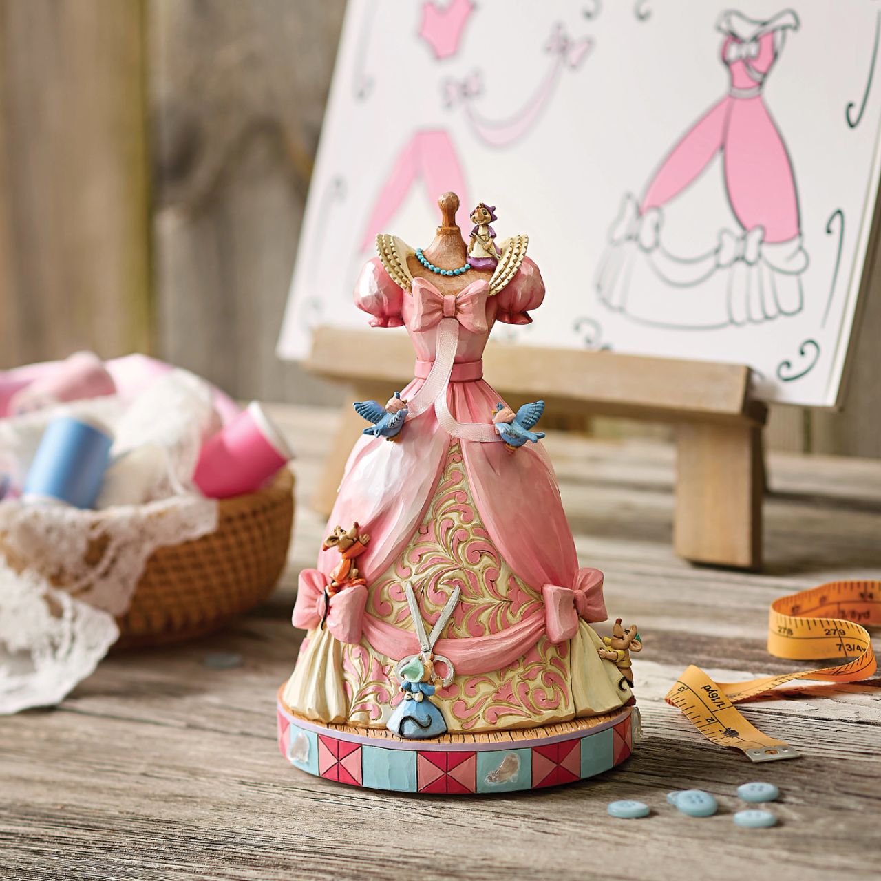 The iconic pink dress from Disney's 1950 masterpiece Cinderella, has been reimagined by artist Jim Shore. With Cinderellas bird and mouse friends, this beautiful dress comes to life. To make this figurine even more special, it plays A Dream is a Wish Your Heart Makes from the film.