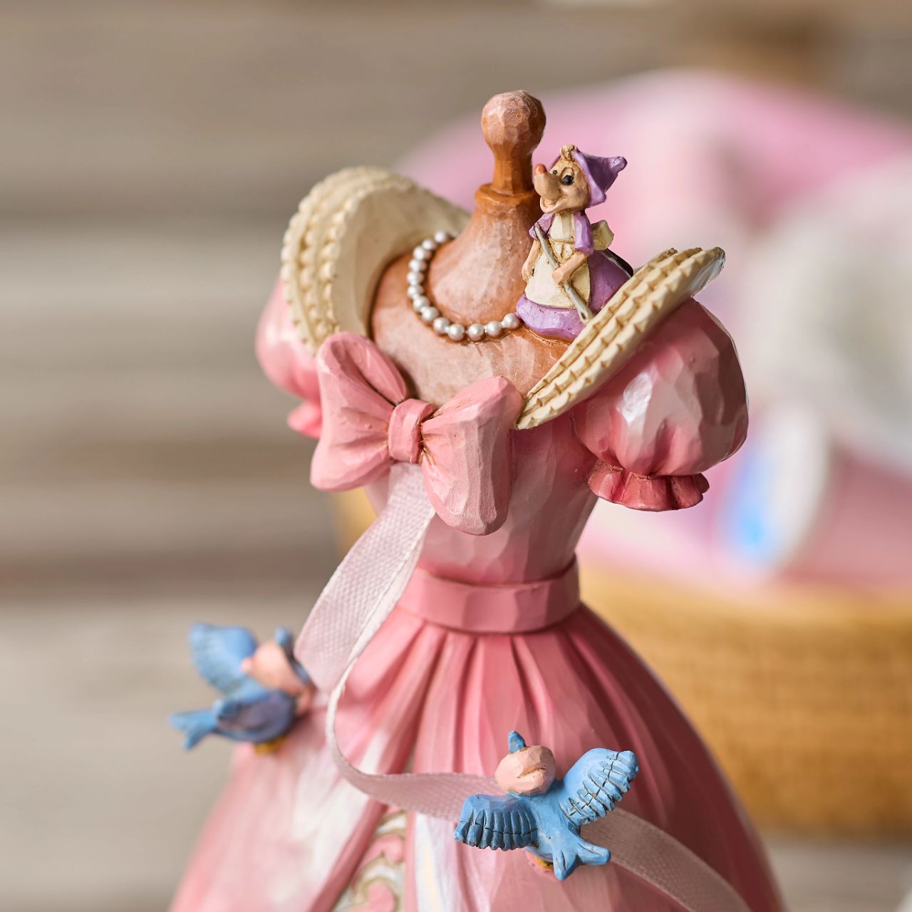 The iconic pink dress from Disney's 1950 masterpiece Cinderella, has been reimagined by artist Jim Shore. With Cinderellas bird and mouse friends, this beautiful dress comes to life. To make this figurine even more special, it plays A Dream is a Wish Your Heart Makes from the film.