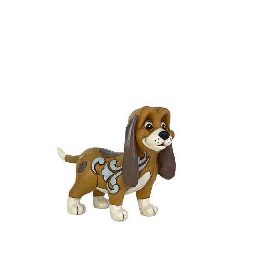 This darling Jim Shore miniature features Copper, the hound, with intricate rosemaling patterns and a heartfelt expression. He's likely on the lookout for his pal, the Fox, ready for their next adventure together in the woods.