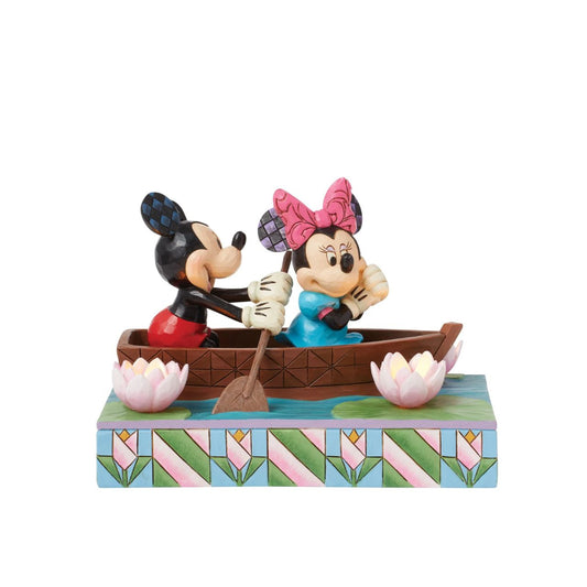 Disneys Mickey and Minnie Mouse are sailing on love in this sweet, light-up figurine from the Disney Traditions by Jim Shore.