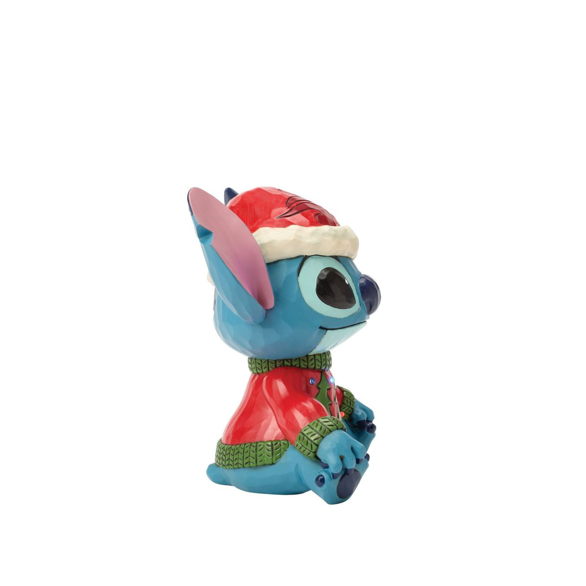 Stitch brings holiday humour to life in this glowing Jim Shore bust with an LED lit Christmas sweater. Wearing his sweater and Santa hat with a smile, the mischievous alien proves holiday magic spans across the universe with festive folk art style.