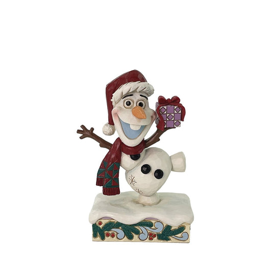 In this joyful Jim Shore design, Olaf dances merrily in the snow with a wide smile, donning a Santa hat and a festive scarf while carrying a colourful present. Adorned with charming rosemaling details, this delightful piece captures holiday cheer.