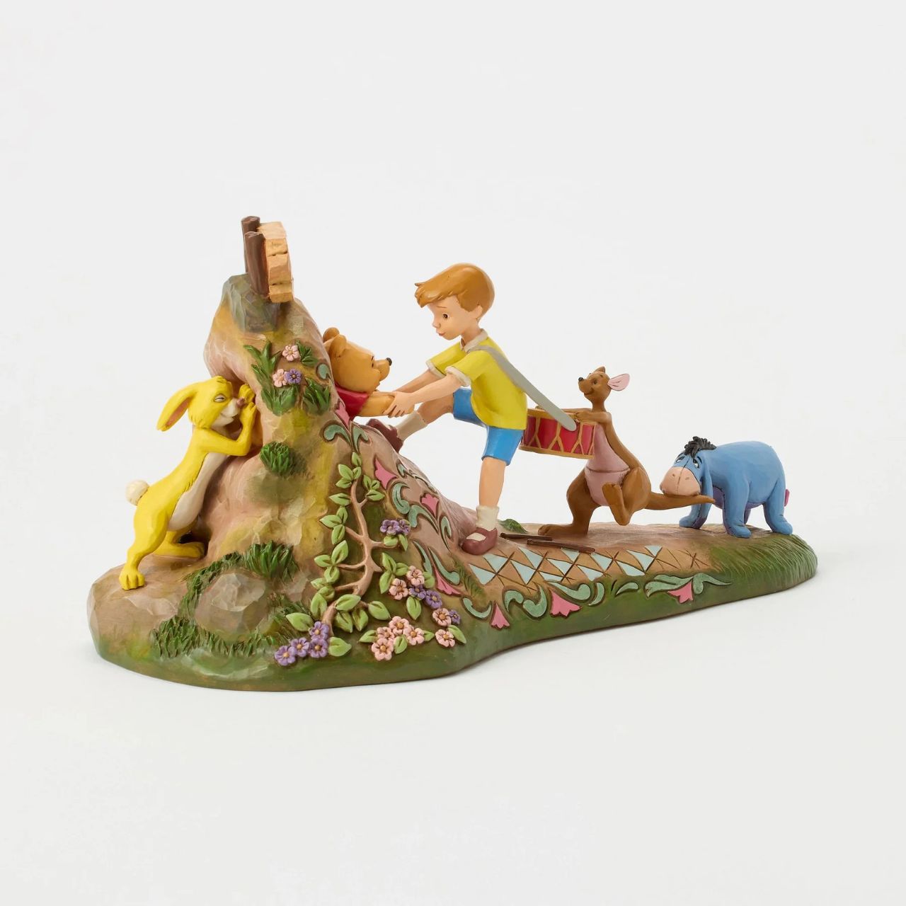 After a celebration in the Hundred Acre Wood, Pooh needs a little help exiting Rabbit's House. Christopher Robin, Kanga, and Eeyore pull Pooh's hands while Rabbit pushes from behind. Adorned with Jim Shore's iconic detailing and soft floral accents.