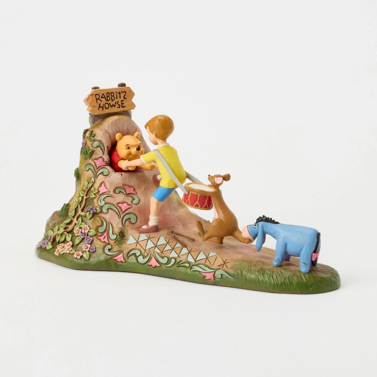 After a celebration in the Hundred Acre Wood, Pooh needs a little help exiting Rabbit's House. Christopher Robin, Kanga, and Eeyore pull Pooh's hands while Rabbit pushes from behind. Adorned with Jim Shore's iconic detailing and soft floral accents.