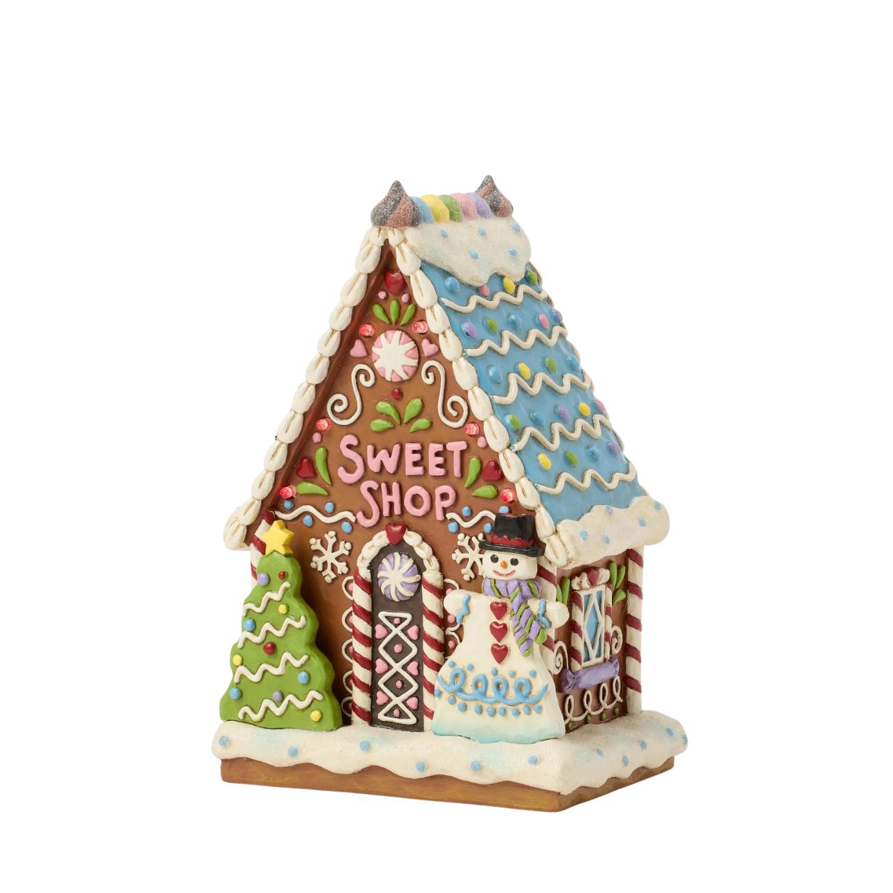 This enchanting Jim Shore LED light-up sweet shop invites you into a festive gingerbread house with colourful icing, cookies, and candy. Glowing warmly, it promises a world of delicious treats and holiday cheer, making it a delightful centerpiece.