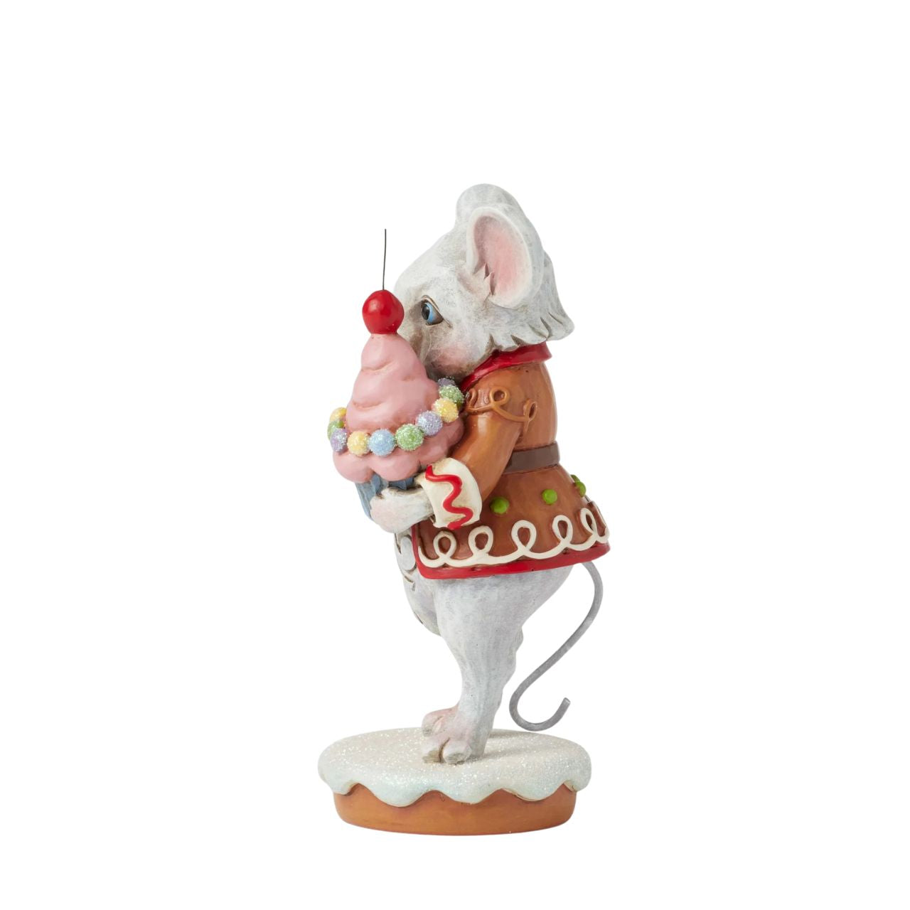 This charming Gingerbread Christmas mouse by Jim Shore offers you a delightful cupcake topped with a bright red cherry. Dressed in a festive gingerbread coat adorned with icing details, his sweet smile and cheerful spirit, brings a touch of whimsy to you.