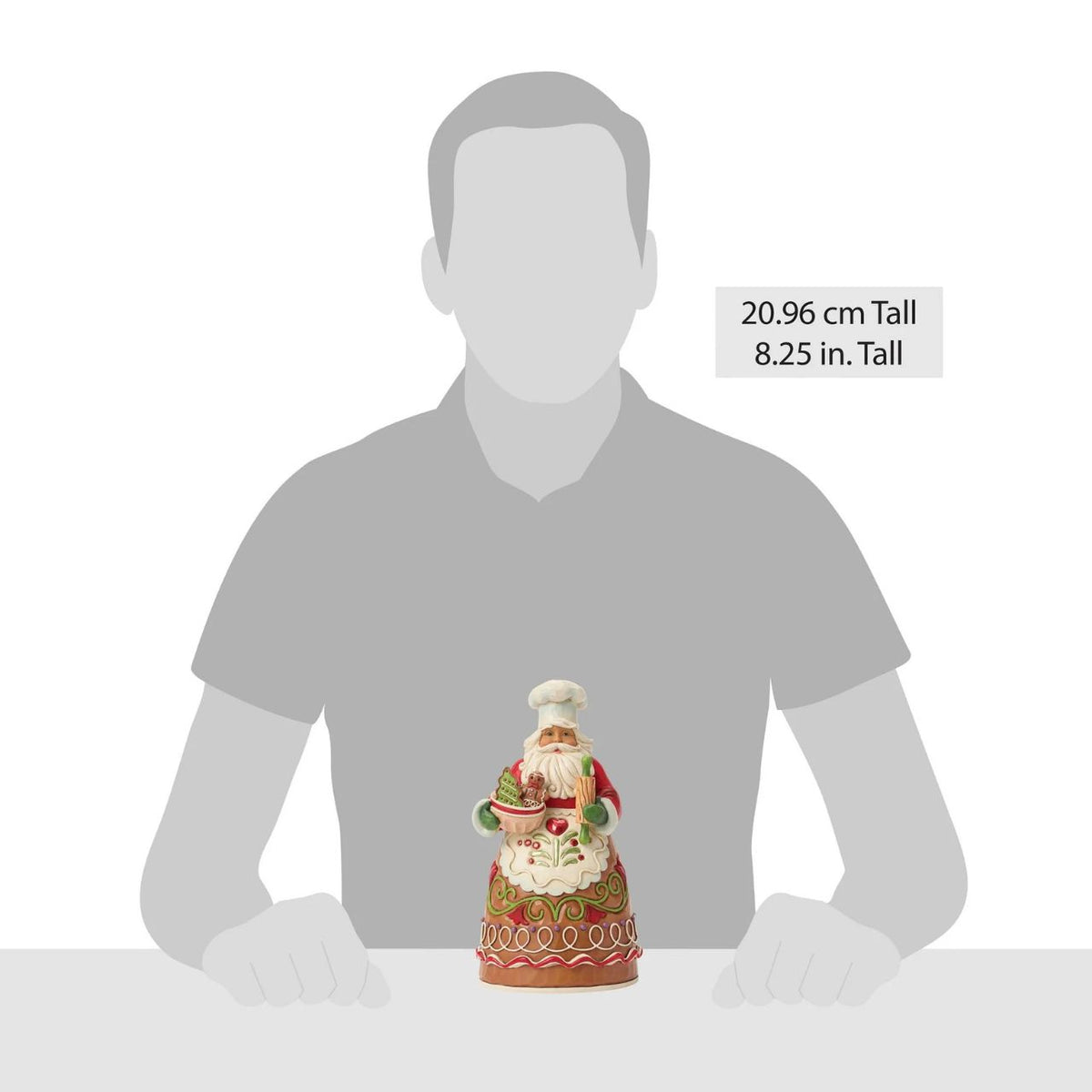 Dressed in a chef's hat and apron, this gingerbread Santa is ready to bake up Christmas joy. Jim Shore's playful patterns and candy-like details give the design a delightful, sugar-coated charm. A treat for both collectors and holiday kitchens alike.