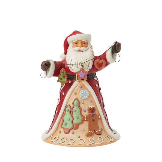 Santa brings the Gingerbread Christmas holiday spirit in this Jim Shore design, holding a string of decorated Christmas cookies. What a joyful smile, Santa presents with his festive garland, while his cloak features a scene of colourful cookies with icing decorations.