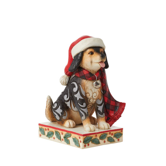 Heartwood Creek Highland Glen Dog in Santa Hat Figurine  Designed by award winning artist Jim Shore as part of the Heartwood Creek Highland Glen Collection, hand crafted using high quality cast stone and hand painted, this cute & cosy dog is perfect for the Christmas season.