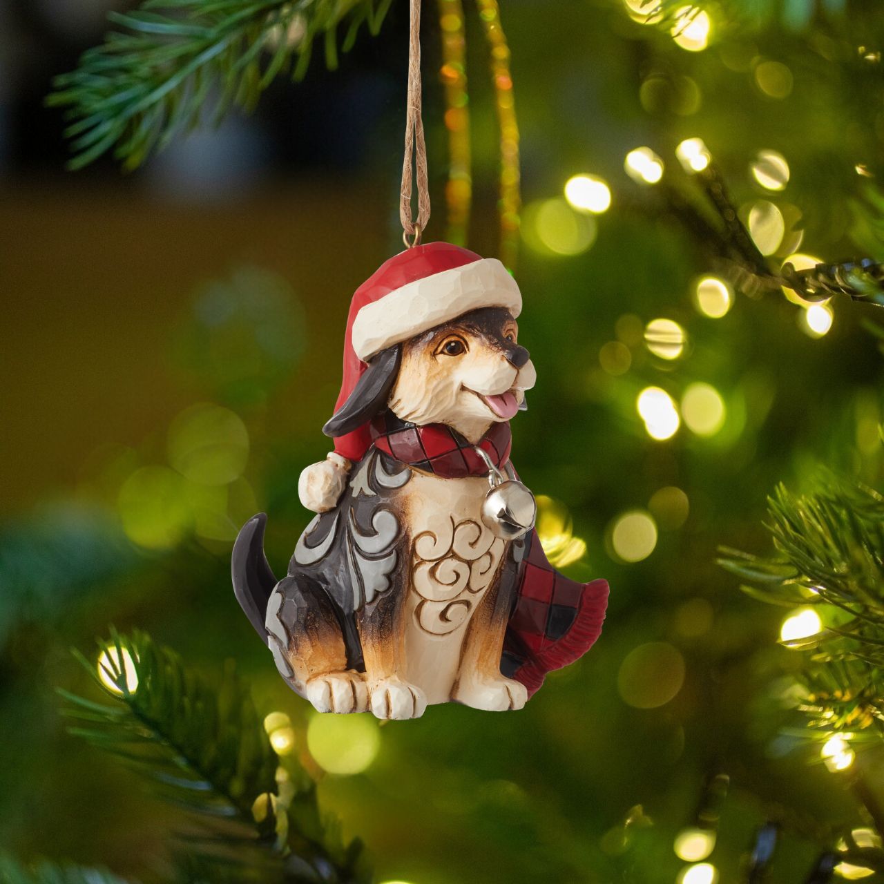 Heartwood Creek Highland Glen Dog in Scarf Hanging Ornament  Designed by award winning artist Jim Shore as part of the Heartwood Creek Highland Glen Collection, hand crafted using high quality cast stone and hand painted, this cute dog hanging ornament is perfect for the Christmas season. Packaging: Full colour, fully branded gift box with photo.