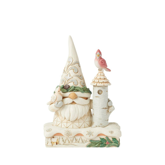 This charming Jim Shore White Woodland design features a delightful gnome dressed in white, standing beside a birch tree birdhouse. With two cardinals enjoying his sweet company, the piece beautifully captures the warmth and joy of winter wildlife.