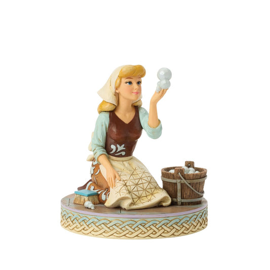 Cinderella's spirit remains unbroken in this inspiring Jim Shore scene. Dressed as a maid, she finds joy in her work, catching a bubble as she scrubs the floors. Jim Shore's enchanting details capture her beauty and resilience.