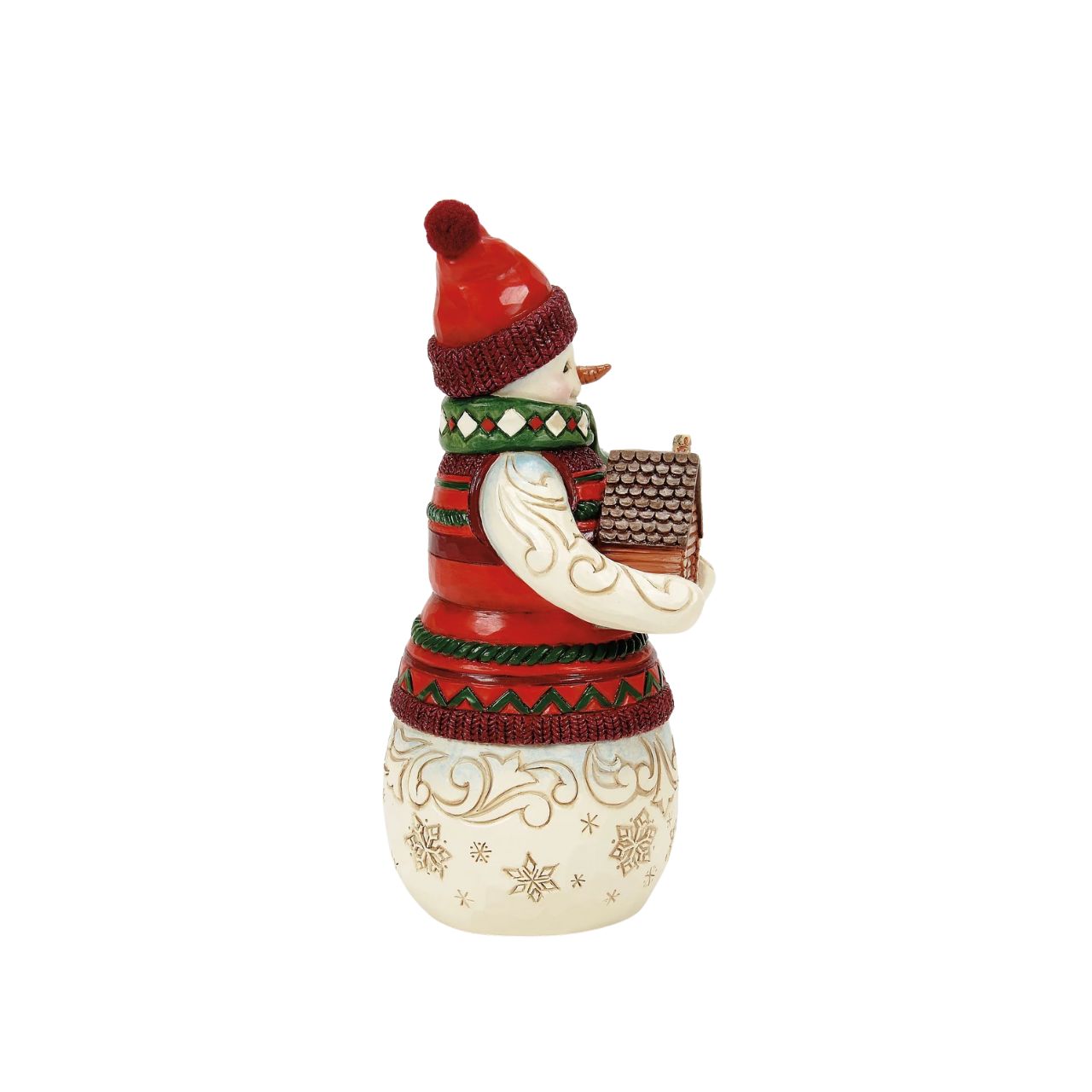 This Christmas at the Lodge Jim Shore snowman is dressed in an intricate red and green tunic and holds a little log cabin. With a knit cap, rosy cheeks, and a joyful smile, he glows with rosemaling and snowflakes, bringing festive warmth and cosy cabin vibes.