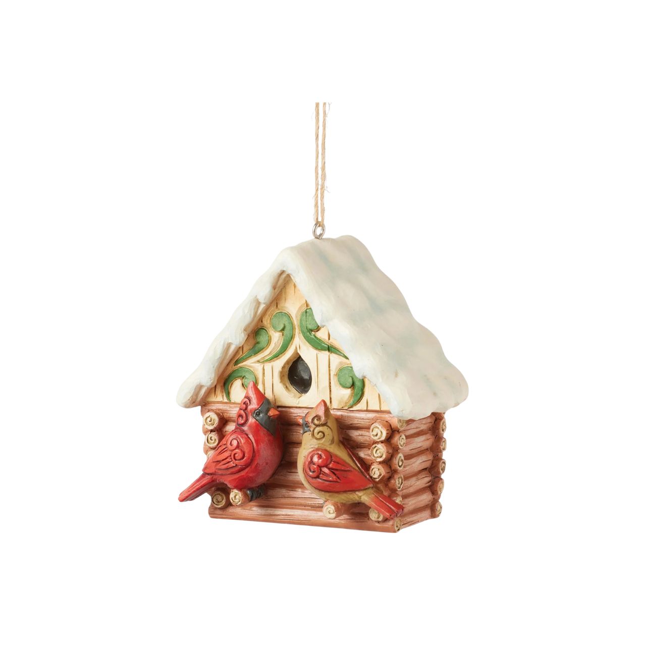 This Christmas at the Lodge enchanting Jim Shore ornament showcases a charming birdhouse designed to resemble a miniature log cabin, complete with Jim Shore's iconic rosemaling. Perched are a pair vibrant cardinals that add a touch of love.
