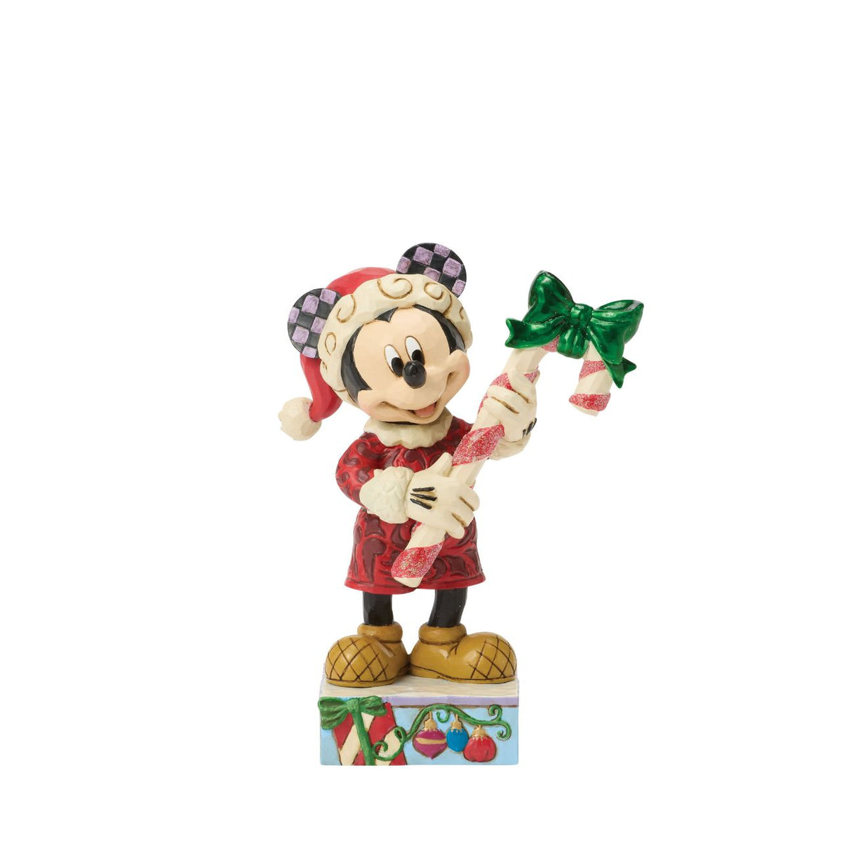 Mickey holds a giant candy cane in this festive Jim Shore design. With a playful pose, Mickey is dressed in a Santa hat and red coat with rosemaling details, he adds a touch of holiday sweetness and Disney magic to your Christmas traditions.