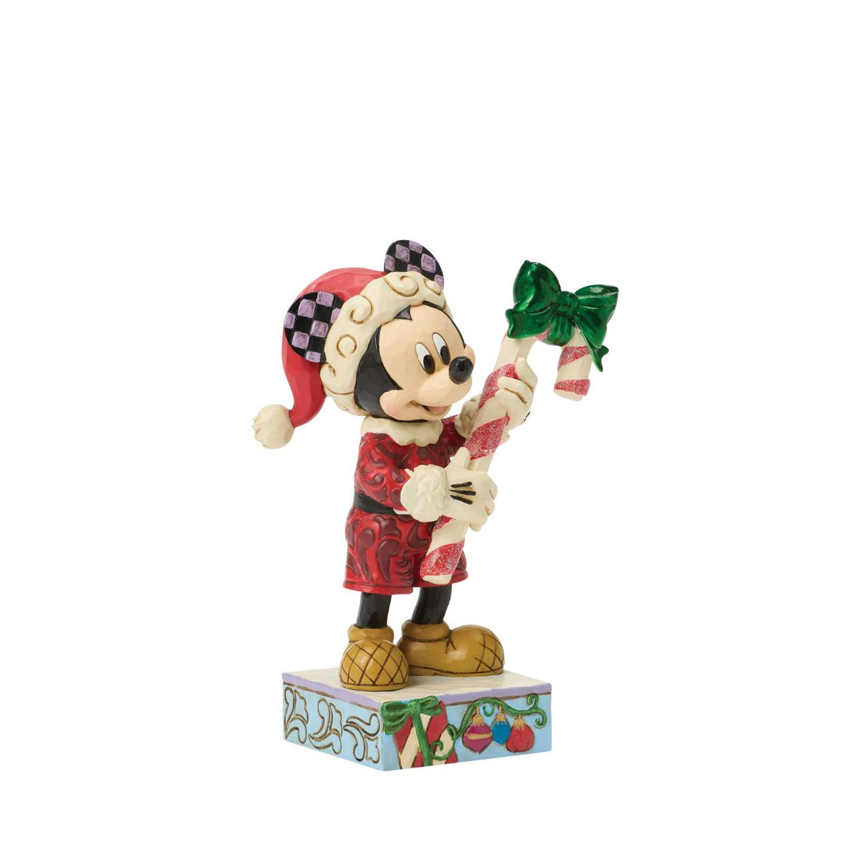 Mickey holds a giant candy cane in this festive Jim Shore design. With a playful pose, Mickey is dressed in a Santa hat and red coat with rosemaling details, he adds a touch of holiday sweetness and Disney magic to your Christmas traditions.