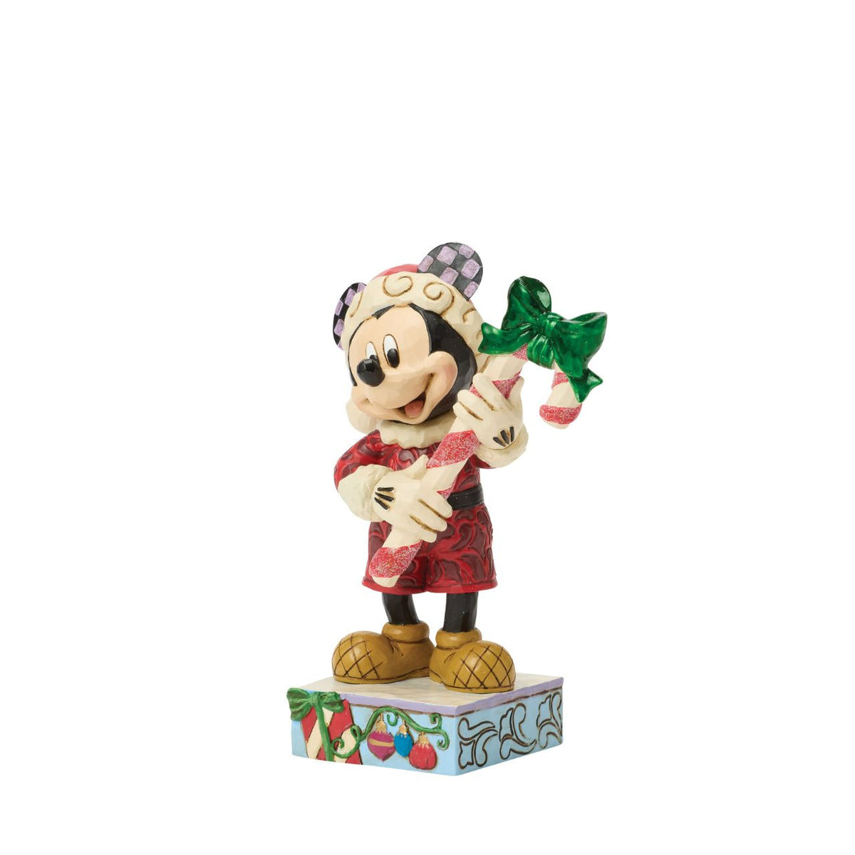 Mickey holds a giant candy cane in this festive Jim Shore design. With a playful pose, Mickey is dressed in a Santa hat and red coat with rosemaling details, he adds a touch of holiday sweetness and Disney magic to your Christmas traditions.