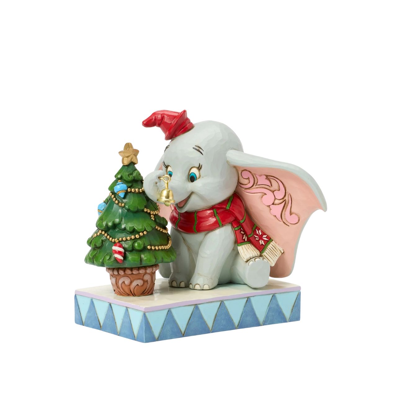 In this heartwarming Jim Shore scene, Dumbo is festively dressed in a red coat and hat as he joyfully decorates a miniature Christmas tree with a real working bell in his trunk. Capture the spirit of the season with Dumbo's playful spirit.