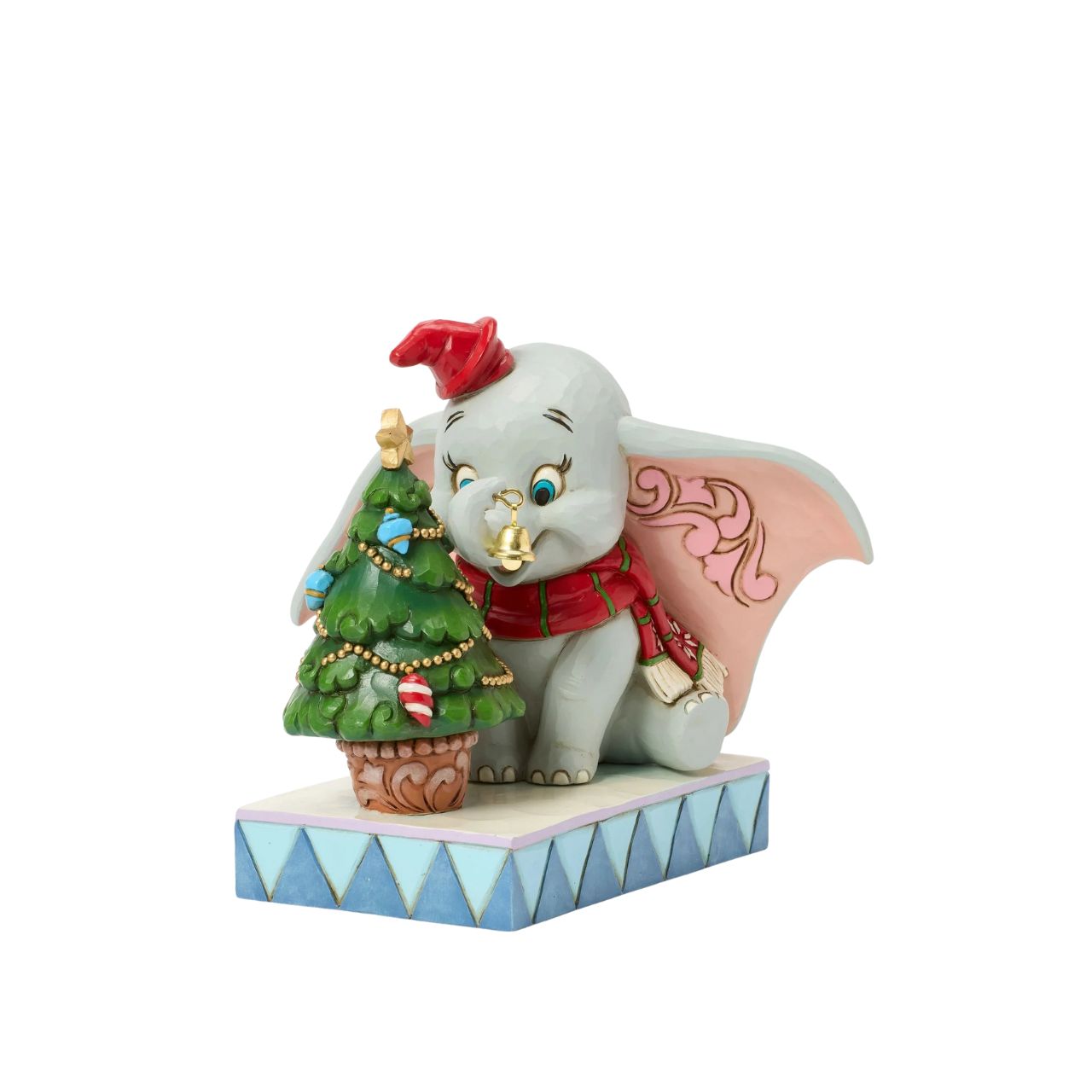In this heartwarming Jim Shore scene, Dumbo is festively dressed in a red coat and hat as he joyfully decorates a miniature Christmas tree with a real working bell in his trunk. Capture the spirit of the season with Dumbo's playful spirit.