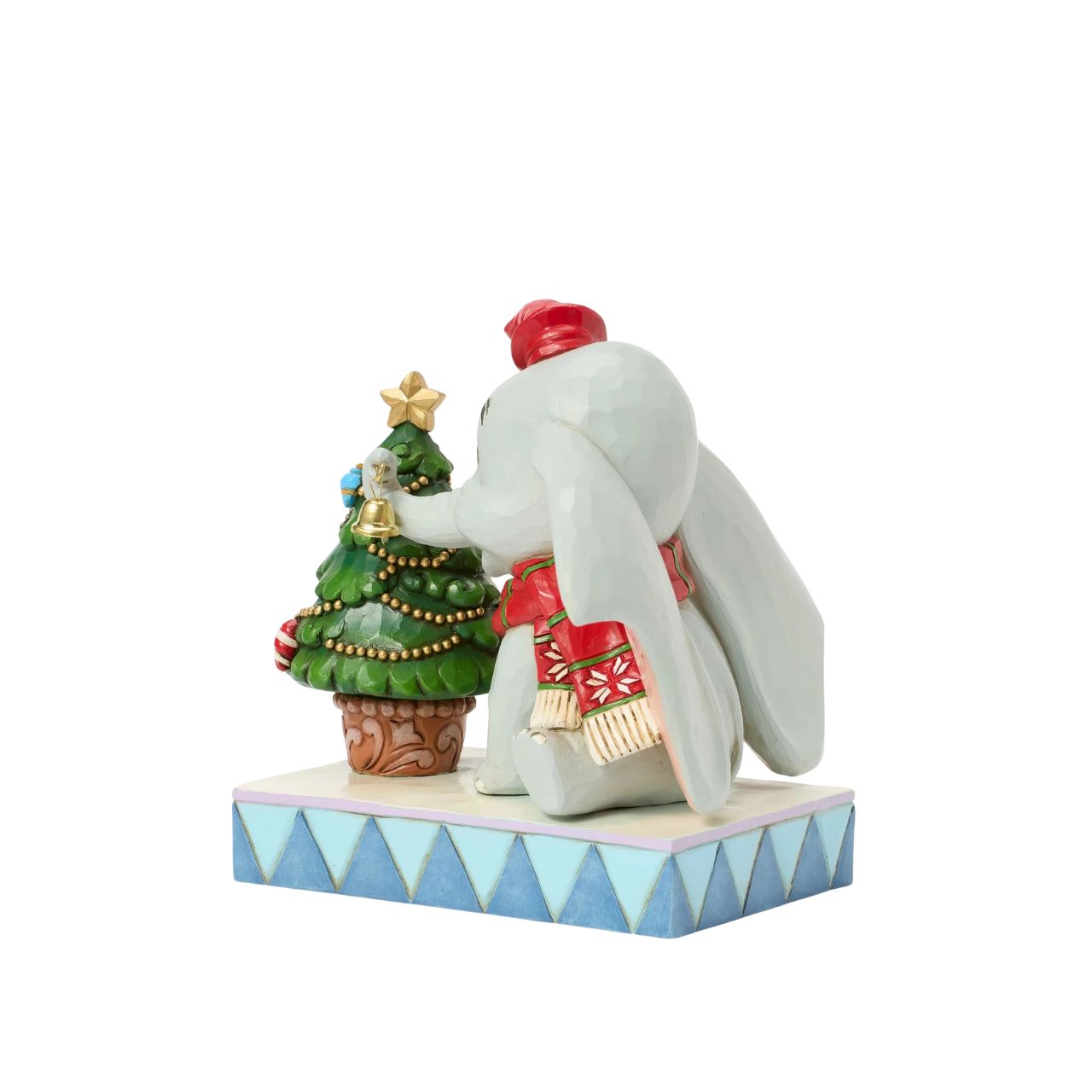 In this heartwarming Jim Shore scene, Dumbo is festively dressed in a red coat and hat as he joyfully decorates a miniature Christmas tree with a real working bell in his trunk. Capture the spirit of the season with Dumbo's playful spirit.