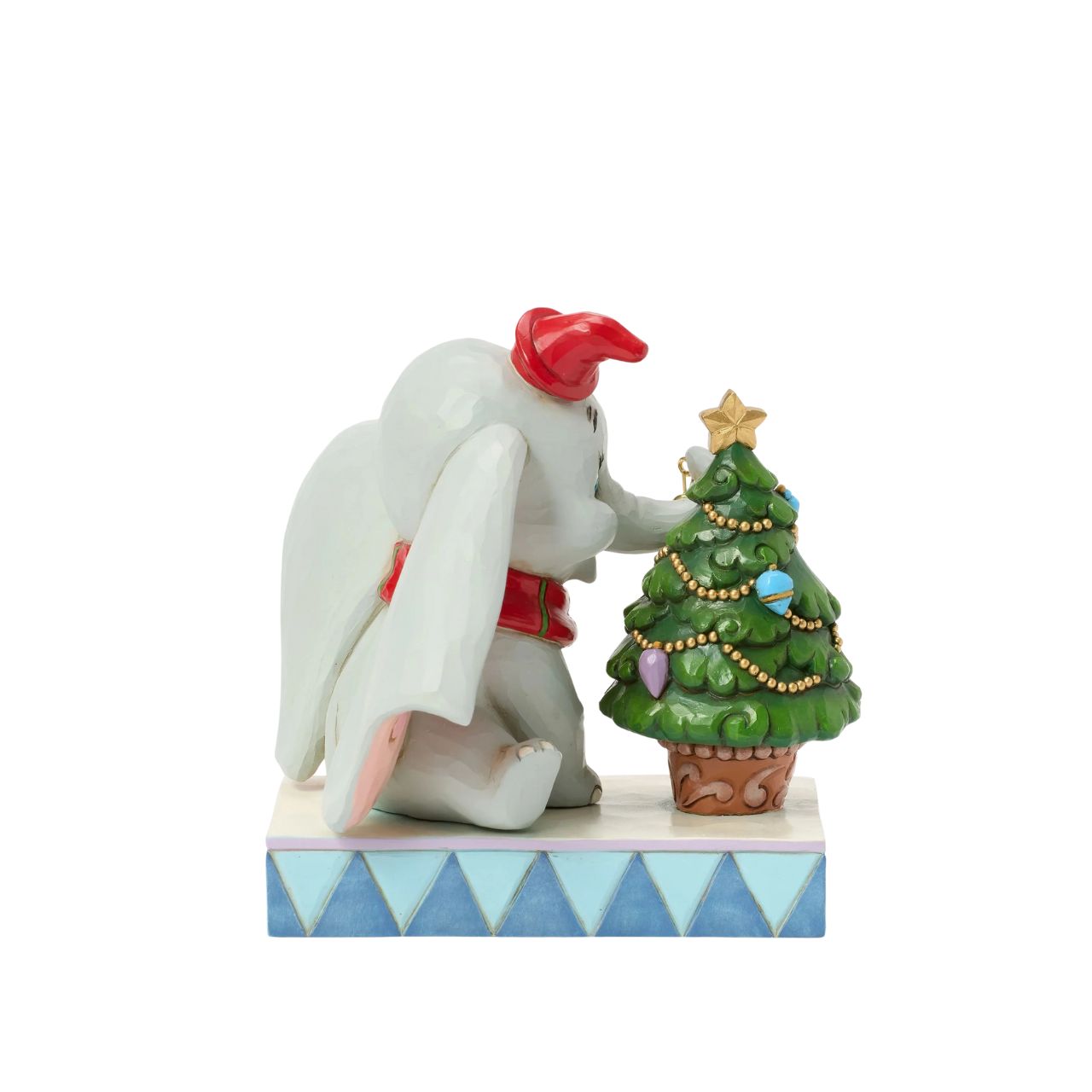 In this heartwarming Jim Shore scene, Dumbo is festively dressed in a red coat and hat as he joyfully decorates a miniature Christmas tree with a real working bell in his trunk. Capture the spirit of the season with Dumbo's playful spirit.