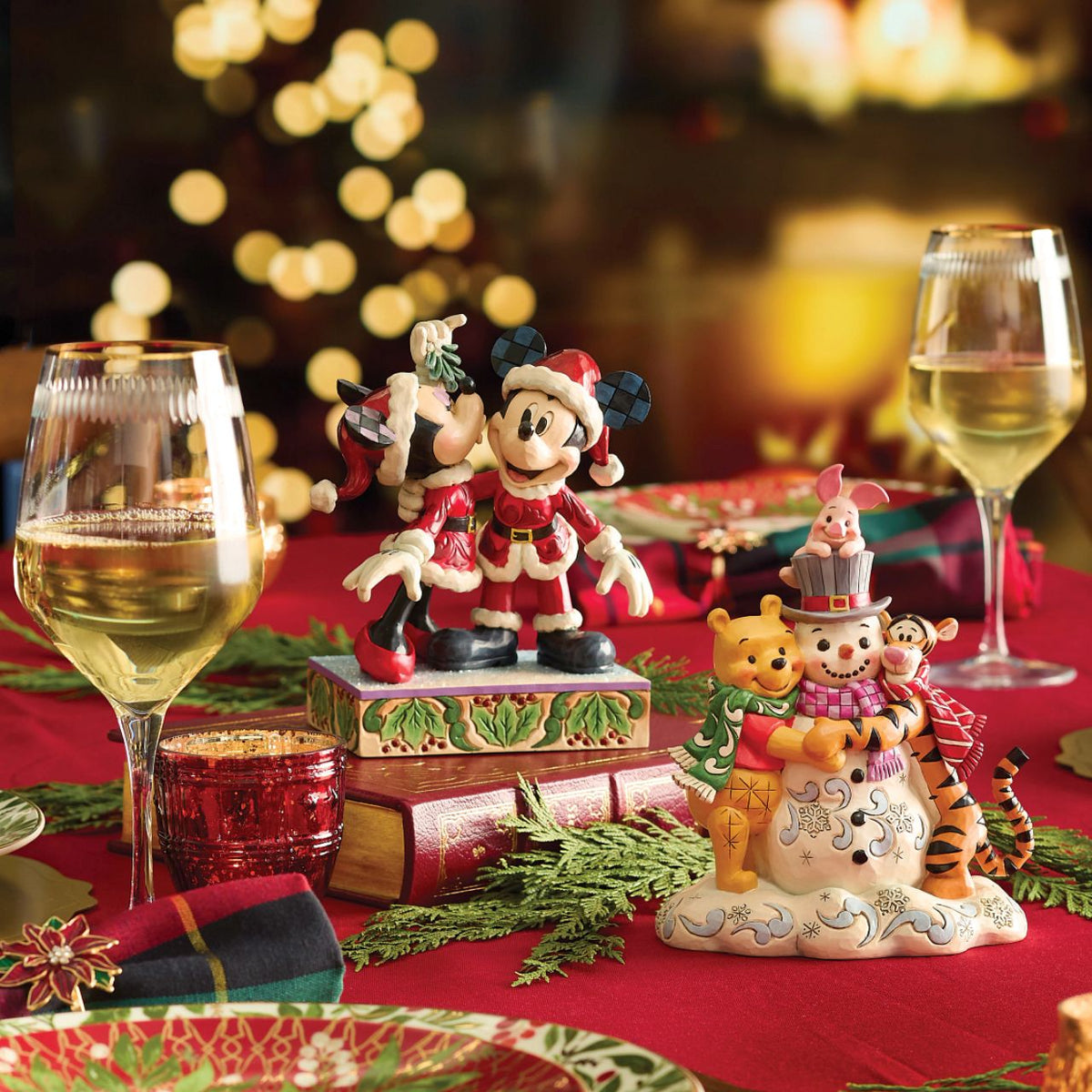Romance fills the air as Mickey and Minnie Mouse share a kiss beneath the mistletoe in this darling Jim Shore creation. With festive details and folk art charm, it's a heartwarming reminder of holiday love and cheerful Christmas traditions.