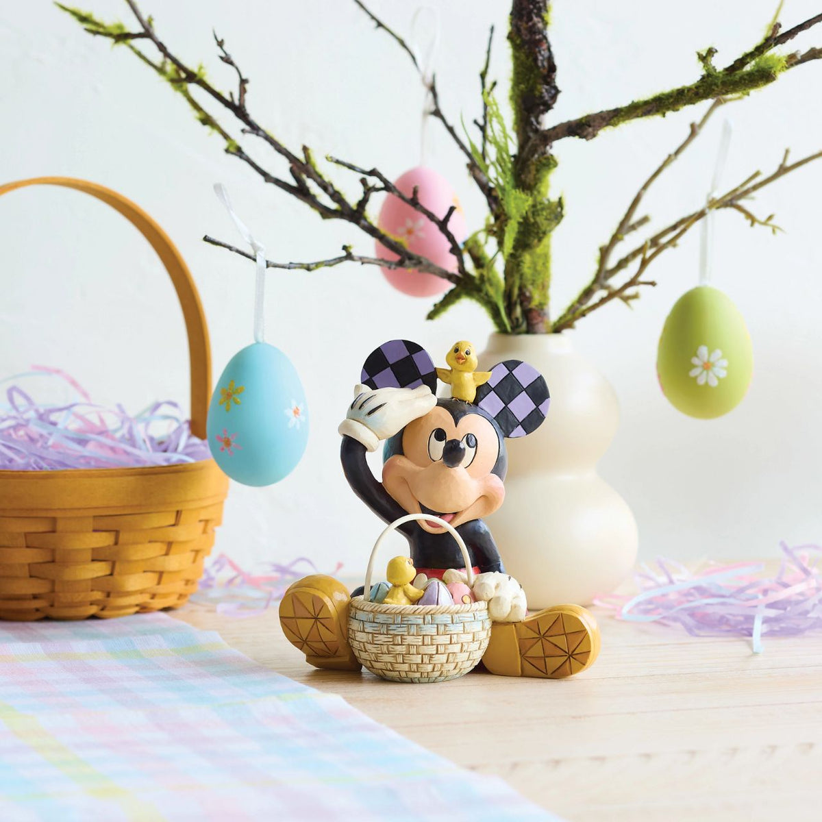 Mickey celebrates spring with an Easter basket full of painted eggs in this festive Jim Shore scene. Two playful chicks join in the fun as Mickey rummages through the basket, accented with Jim Shore's signature rosemaling and patterning.