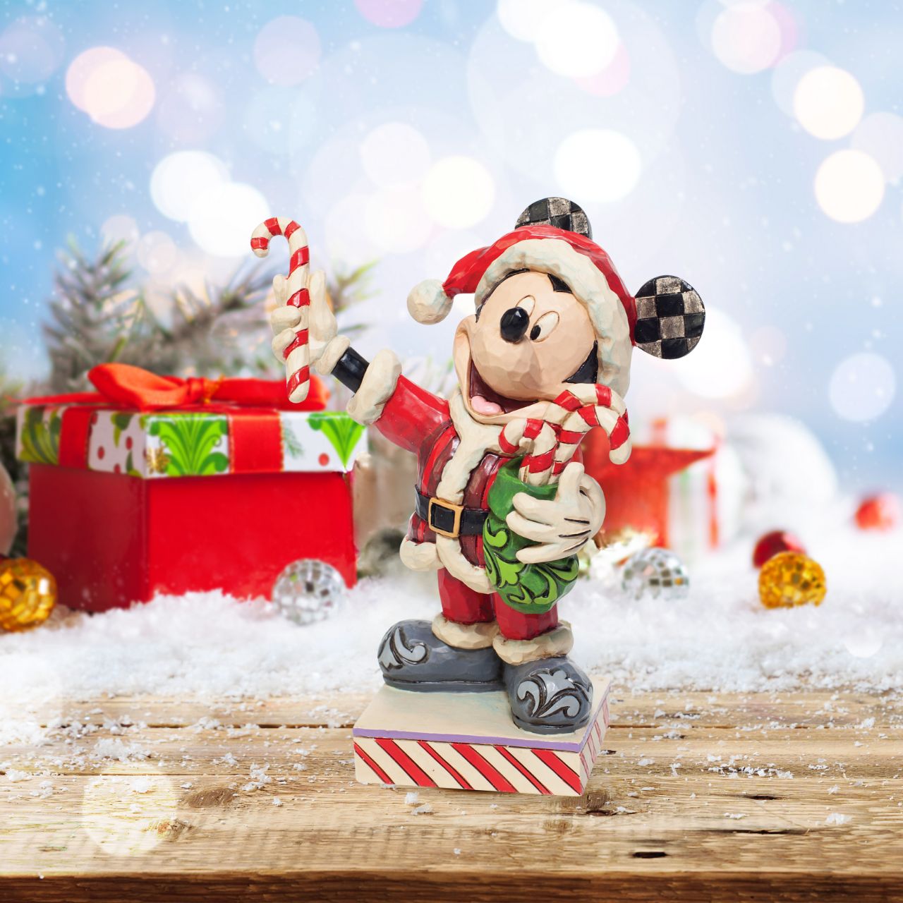 Disney Mickey Mouse with Candy Canes Figurine  Dressed in a Santa suit, Mickey masquerades as the holiday titan. Delivering candy canes to all the nice people he knows, he brings the spirit of Christmas wherever he goes.
