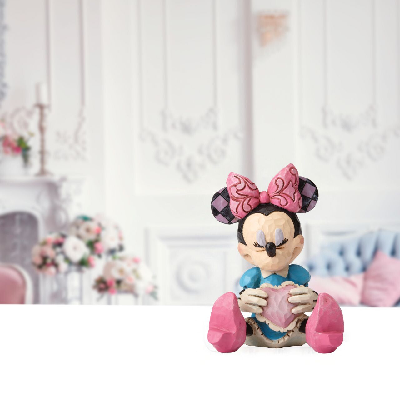 Disney Showcase Minnie Mouse with Heart Mini Figurine  Beautifully handcrafted with delightful attention to detail, Jim Shore's charming miniatures capture the essence of the beloved Disney characters. Making a wish on a heart held close, this beguiling Minnie is a heartfelt and playful romantic design.