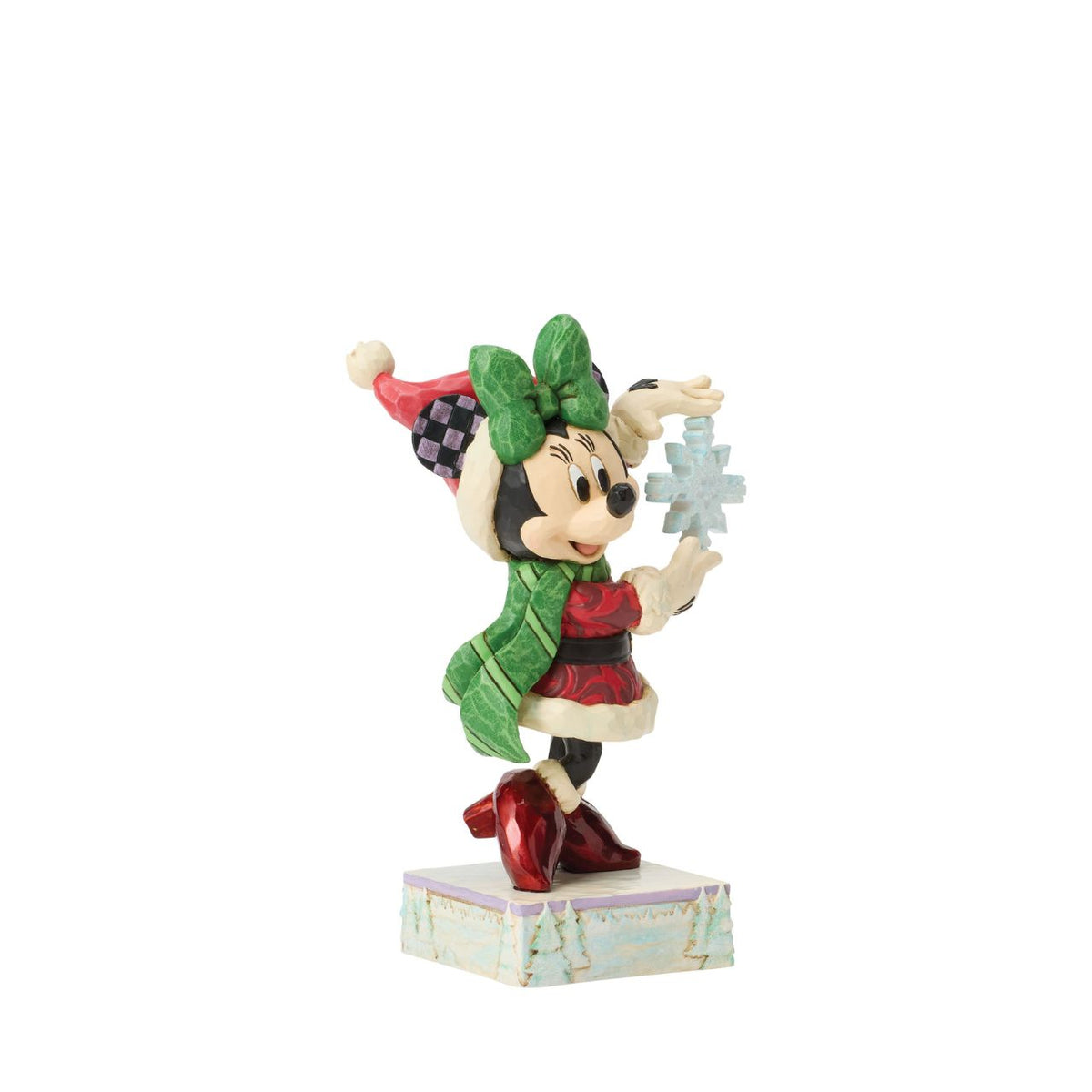 Minnie Mouse sparkles in holiday style as she holds a delicate snowflake in this Jim Shore masterpiece.