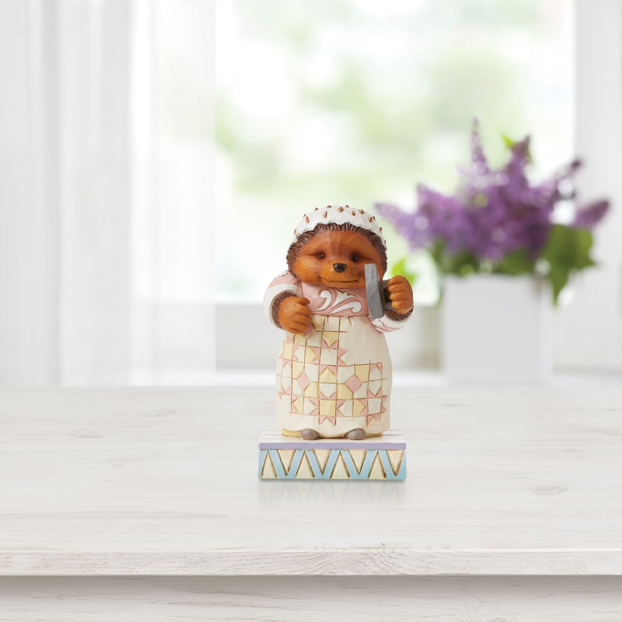 This Jim Shore figurine features the sociable hedgehog, Mrs. Tiggy-Winkle smiling sweetly, with iron in hand.
