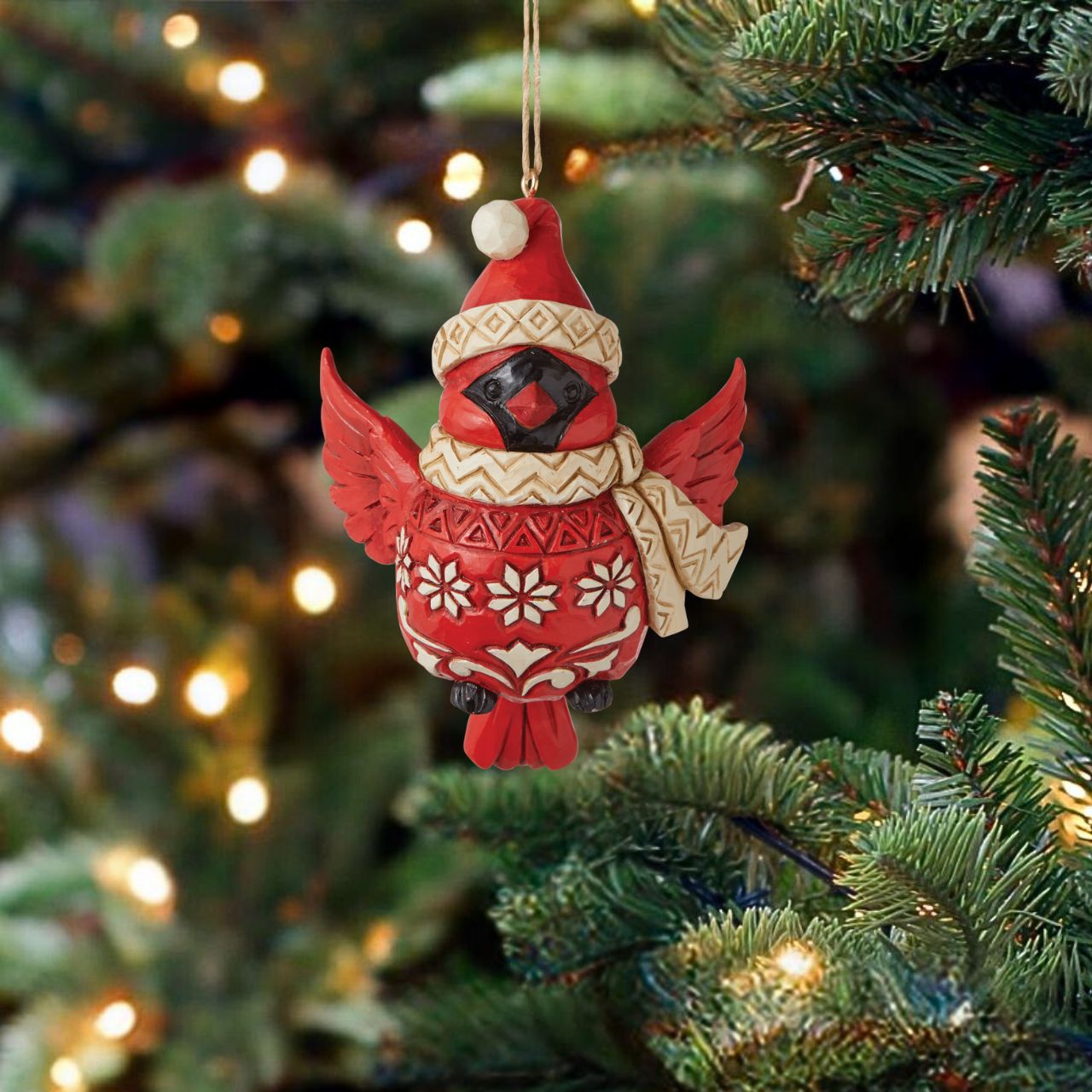 Nordic Noel Cardinal Christmas Hanging Ornament  Tweet your heart out alongside this cheery cardinal ornament. Wearing a patterned Santa hat and matching scarf, this charismatic cutie seems to flutter between your tree's branches with holiday excitement. With folksy patterned plumage, he soars.