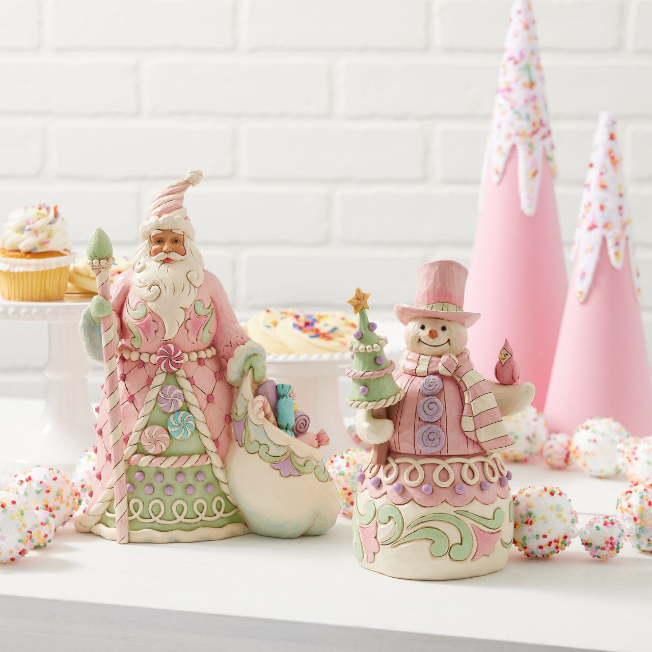 This whimsical Heartwood Sweets pastel pink snowman by Jim Shore radiates charm with his rosemaling patterns, sprinkles, and icing details, embodying the essence of holiday cheer. He lovingly holds a decorated tree and a cardinal.