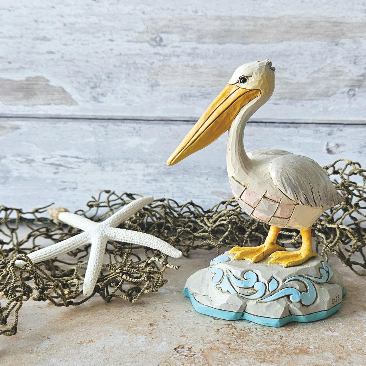 Embrace coastal charm with this magnificent Jim Shore pelican figurine, adorned with the artist's distinctive patchwork patterning, capturing the essence of seaside beauty. This stunning piece brings a touch of coastal elegance to any space.