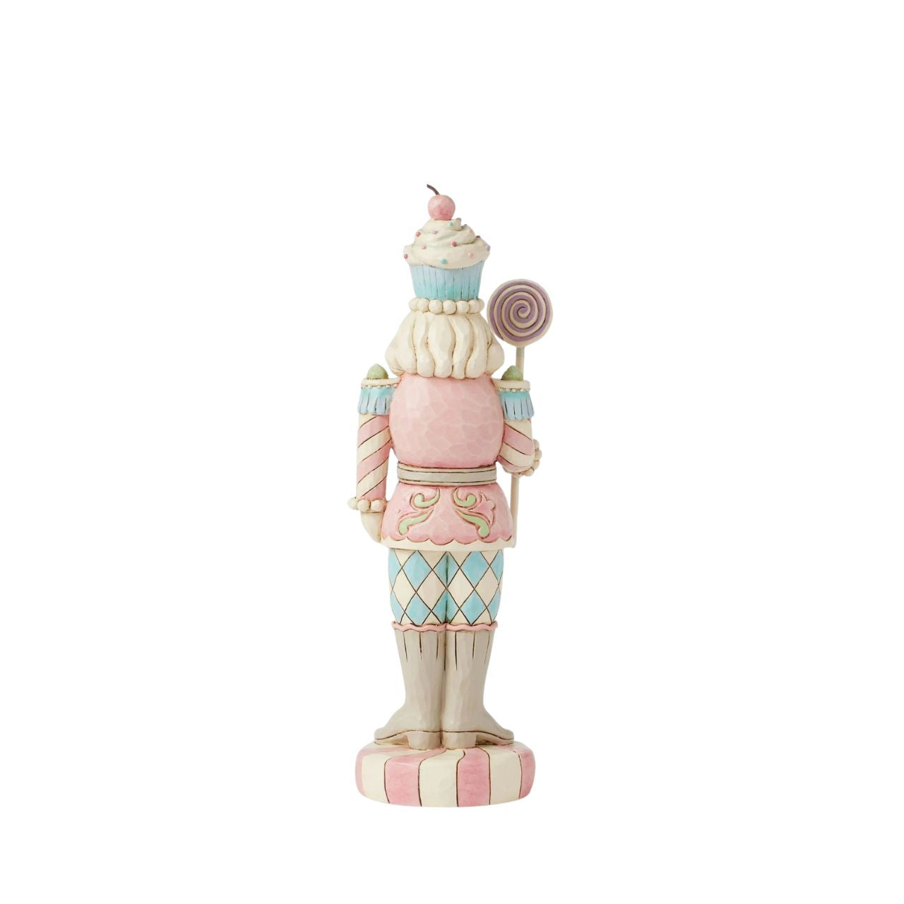 This Heartwood Sweets toy soldier design by Jim Shore stands proudly on a peppermint base, holding a lollipop staff. With a pastel-patterned uniform of icing and gumdrops, complete with a peppermint belt buckle and a delightful cupcake hat, he brings sweet presence to any holiday scene.