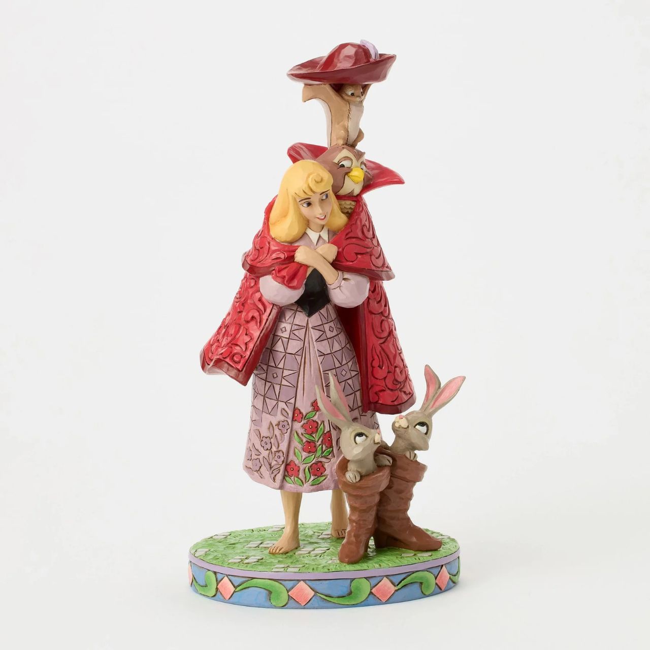 Aurora's forest friends transform into a man in a red coat as she searches for her prince. An owl, squirrel, and bunnies inside boots add charm to this captivating Jim Shore design, bringing the memorable movie scene to life with enchantment.